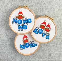 three cross stitch hoop art designs with santa hats