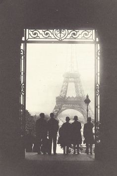 an old photo of people standing in front of the eiffel tower