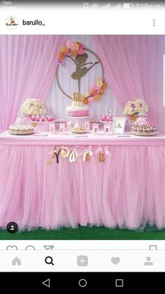 a table topped with lots of pink and gold desserts next to a curtained wall