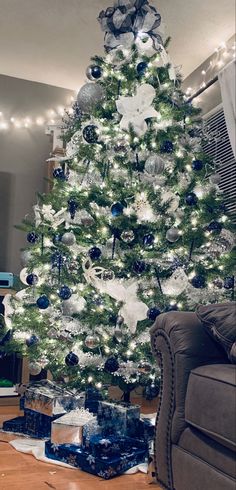 a white christmas tree with blue and silver ornaments