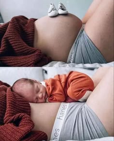 a baby wrapped in a blanket laying on top of it's stomach next to the belly of a pregnant woman