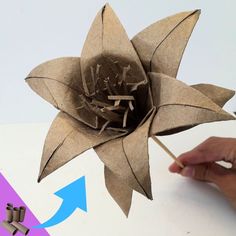 someone is making a flower out of brown paper