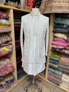 Introducing our Ivory Open Jacket Sherwani with Thread Work and Button Down Kurta Inside, enhanced with Mirror Work and Red Hints All Over the Sherwani, a luxurious and stylish traditional garment perfect for weddings or any special occasion. Made from high-quality materials, this sherwani features intricate thread wor Designer Off White Sets With Zari Work, Wedding Suits With Dabka And Traditional Drape, Dabka Embellished Wedding Suits With Traditional Drape, Elegant Designer Wear Off White Bandhgala, Traditional Drape Wedding Suits With Dabka, Elegant Designer Off White Bandhgala, Designer Off White Wedding Sets, Elegant Off-white Designer Bandhgala, Designer White Sherwani With Cutdana