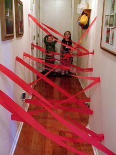 two children are standing in the hallway with red tape