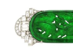 Exhibiting the acme of the Art Deco taste for a lovely symmetrical structure combined with an exotic flair, this jadeite and diamond brooch is more than mere adornment — it is a work of art. A delicate, deep green carved central motif of exceptional quality jadeite features a voluptuous foliate design of fluid lines which stands in divine contrast to the stepped and domed linear designs at each end. The remarkable end pieces feature stunning pavé-set round diamonds paired with geometric emerald- Art Deco Jewelry Brooches, Bijoux Art Deco, Jewellery Marketing, Diamond Brooch, Green Gems, Gold Brooches, Jade Carving, Deco Jewelry, Jade Jewelry