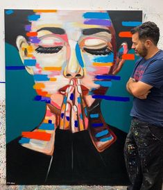 a man standing in front of a painting of a woman's face and hands