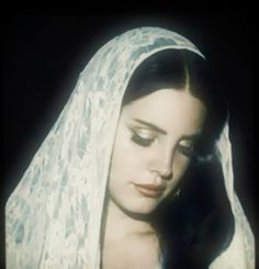 a woman wearing a veil and looking down at her face with an intense look on her face