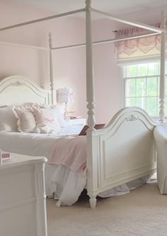 a bedroom with pink walls and white furniture