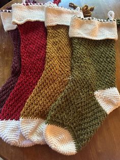 four pairs of knitted socks sitting on top of a wooden table