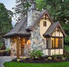 an image of a small house in the middle of some trees and grass with flowers around it