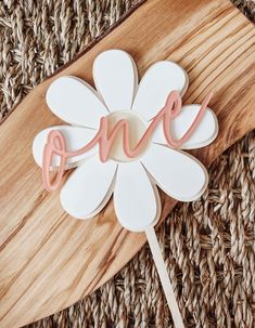 a cake topper with the word love on it sitting on a wooden board next to a piece of wood