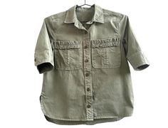 Vintage Cotton Canvas Faded Army Green Button Up Short Sleeve Shirt Size S Women  Measurements:  Chest: 36 inches Shoulders at the back: 16 inches Sleeve length: 11 1/2 inches Length of the shirt at the back: 22 1/2 inches Material: Cotton canvas This item is vintage. Used. Good vintage condition. Spring Utility Washed Tops, Utility Collared Top With Buttons, Utility Style Khaki Tops With Buttons, Khaki Utility Tops With Buttons, Khaki Utility Top With Button Closure, Khaki Short Sleeve Blouse With Pockets, Summer Utility Button-up Top, Summer Washed Shirt For Workwear, Khaki Button-up Blouse With Pockets