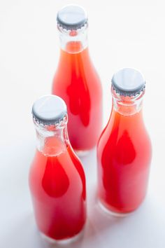 three small bottles with red liquid in them