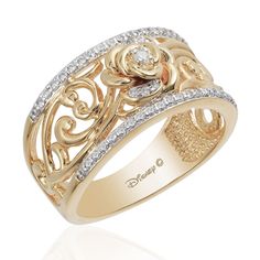 a yellow gold ring with diamonds on the sides and an intricate design in the middle