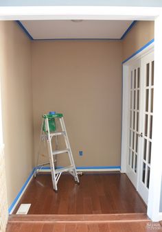 an empty room with a ladder and paint roller