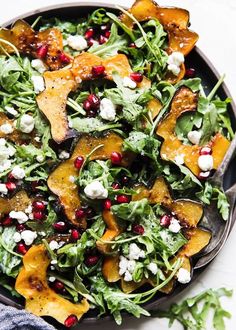 a salad with spinach, feta cheese and pomegranate on top