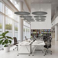 an office with large windows and lots of bookshelves