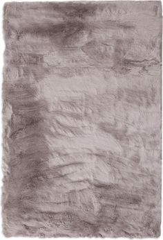 an animal fur rug is shown in grey and white colors, with the background made up of