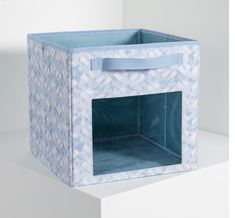 a blue storage box sitting on top of a white shelf