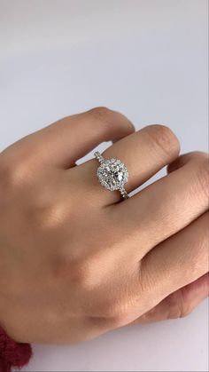 a woman's hand with a diamond ring on top of her left hand,