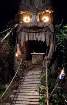 a wooden structure with eyes and lights in the middle of stairs leading up to it