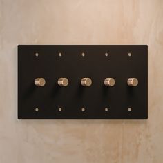 a wall mounted switch plate with five knobs