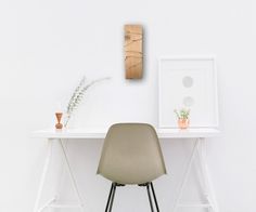 a chair sitting on top of a white desk next to a framed picture and potted plant