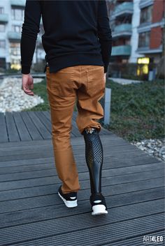 a man walking on a wooden walkway with an umbrella attached to the footrests