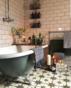 a bath tub sitting next to a fireplace in a bathroom with tiled floors and walls