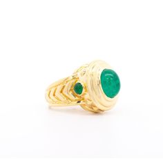 A vintage treasure featuring a stunning 3-carat Colombian emerald cabochon set in 20K yellow gold. The cabochon-cut emerald, exuding rich green hues, commands attention with its captivating sheen.  This ring boasts a unique carved chevron and textured gold design, accentuating its distinguished 20K gold composition. The pointed edges along the ring shank ensure excellent coverage on the finger, ideal for both men and women seeking a statement piece. With its exceptional shine and elevated gold p Colombian Emerald Ring, Emerald Cabochon, Ring Shank, Green Hues, Colombian Emeralds, Rich Green, Yellow Gold Ring, 3 Carat, Gold Texture