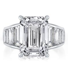 an emerald - cut diamond ring with baguetts on the shoulders and side stones