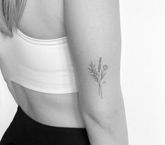 a black and white photo of a woman's arm with a flower tattoo on it