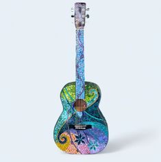 a colorful guitar sitting on top of a white surface