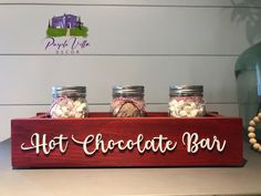 three jars filled with hot chocolate and marsh in front of a sign that says hot chocolate bar