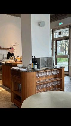 a counter with wine glasses on it in a room next to a table and chairs