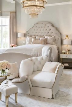 a bedroom with white furniture and chandelier