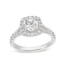 a white gold ring with an oval diamond center and pave set diamonds around the band