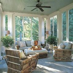 a sun room with wicker furniture and large windows