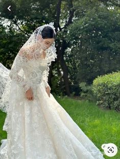 a woman in a wedding dress is posing for the camera with her veil pulled back