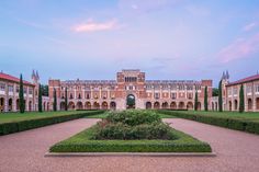 a large building with hedges in front of it and a walkway leading to the entrance