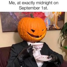 a man in a suit and tie holding a plate with a carved pumpkin on it