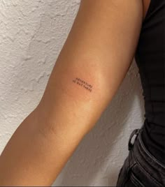 a woman's arm with a small tattoo that reads, i am not here