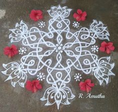 a white and red flower design on the ground with some flowers in front of it