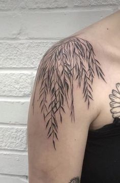 a woman's shoulder with a flower and leaves tattoo on the left side of her arm