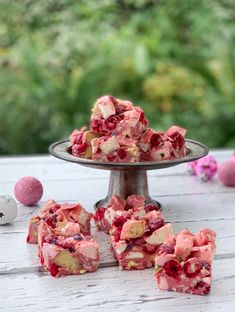 several pieces of cake sitting on top of a table next to some pink and white flowers