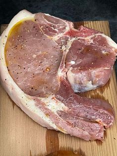 raw meat sitting on top of a wooden cutting board