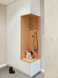 an empty room with some shoes on the floor and a bag hanging from the wall