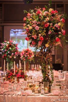 a vase filled with flowers sitting on top of a table covered in plates and glasses