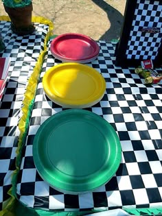 three plates sitting on top of a checkered tablecloth covered table with green and yellow plates