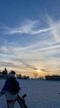 a person standing in the snow holding skis